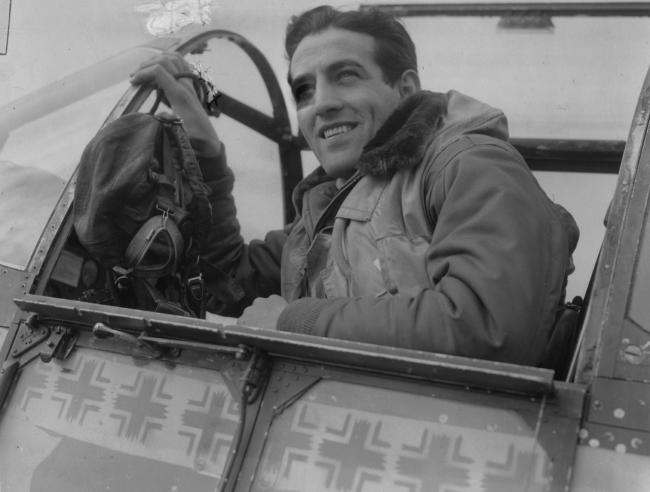 Capt. Don Gentile, of the 4th Fighter Group, in the cockpit of his P-51B Mustang 'Shangri-La' (VF-T, serial no. 43-6913) at Debden air base. Passed by the U.S. Army in April 1944. Printed caption attached to print: 'May Have Broken Rickenbacher's Record. Associated Press photo shows: The new "ace" in the cockpit of his plane, "Shangri-La". Note 21 of his 27 'kills' have been recorded on the side of the plane with the Eagle Squadron insignia and the checkerboard which both Capt. Gentile and his w